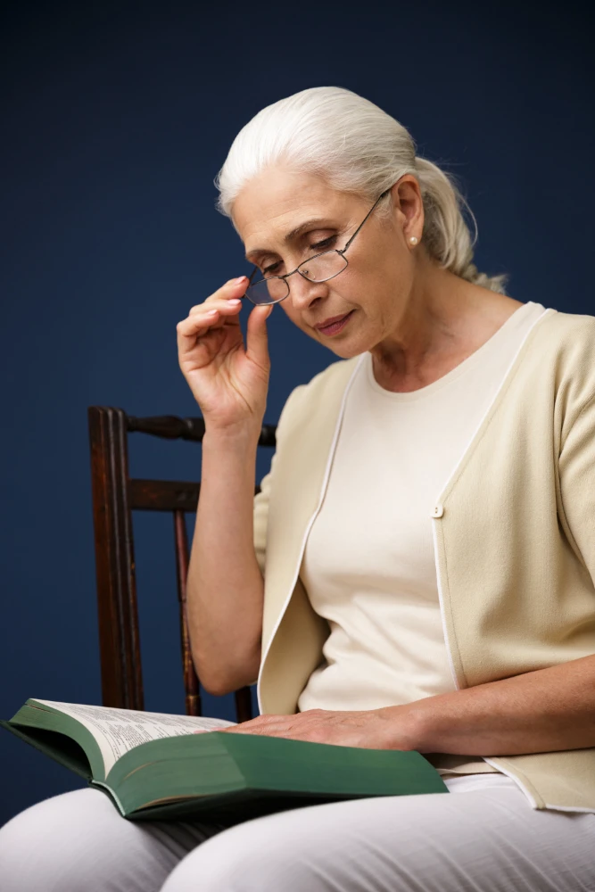 A senior trying to read with her eye wear