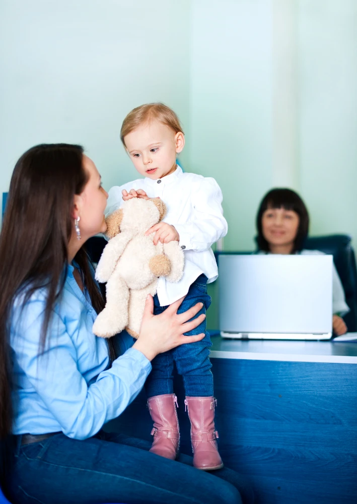 A photo of a child with the supervision of their parent having an eye exam
