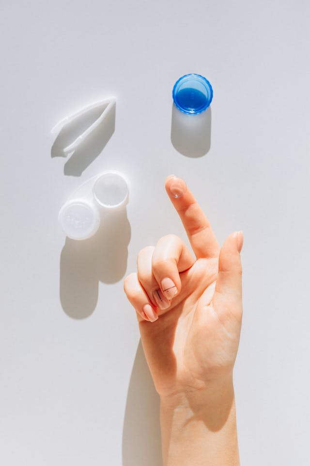 woman holding contacts while using other contact lens instruments