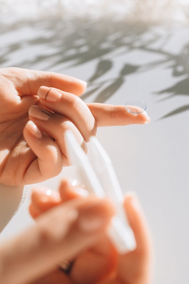 woman holding a contact lens